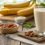Glass of banana almond milk with fresh bananas and almonds