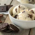 Bowl of creamy cookies and cream ice cream with cookie chunks.