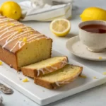 Freshly baked lemon pound cake with lemon glaze on a rustic table.