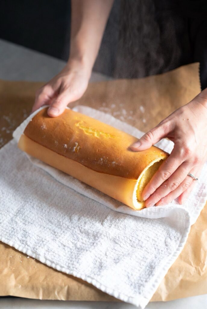 The critical hot-roll technique: rolling the warm sponge cake in a towel prevents cracking when filled